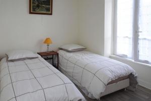2 camas individuales en una habitación con ventana en Apartment Beg Meil, en Fouesnant