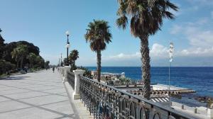 un marciapiede vicino all'oceano con palme di AG sweet apartment a Reggio di Calabria