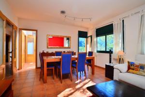 een woonkamer met een eettafel en blauwe stoelen bij SR-2 BEGUR SA RIERA 6 Pax in Begur