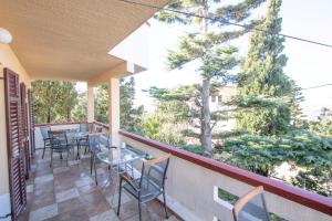 a balcony with tables and chairs and trees at Antodo Alen in Novalja