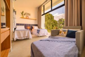 a bedroom with two beds and a large window at Pousada Boutique Mirante dos Adelphos in Socorro +31 photos