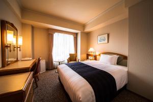 a hotel room with a bed and a desk at Kure Hankyu Hotel in Kure