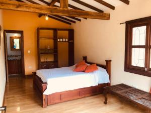 ein Schlafzimmer mit einem Bett mit orangefarbenen Kissen darauf in der Unterkunft Finca Naya in Fredonia