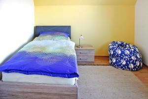 a bedroom with a bed and a dresser with a blue bedspread at Ferienhaus Poseidon mit Meerblick am Breetzer Bodden in Vieregge in Vieregge