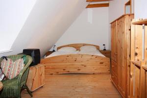 a bedroom with a wooden bed and a chair at Terraced houses in the port village of Vieregge on the island of Rügen in Vieregge