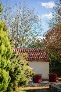 une petite maison avec un toit carrelé dans un jardin dans l'établissement casa akacia, à Telavi