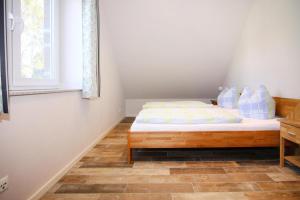 ein kleines Schlafzimmer mit einem Bett und einem Fenster in der Unterkunft Cottage, Trassenheide in Trassenheide