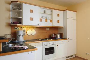 a kitchen with white cabinets and a counter top at Apartments Post Hiddensee Vitte in Vitte