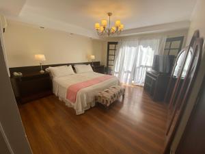 a bedroom with a large bed and a television at Hosteria del Bosque in Necochea +19 photos
