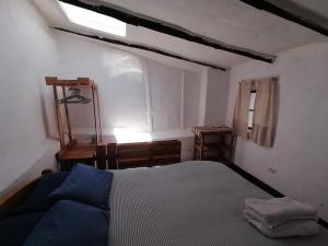 una piccola camera da letto con un letto e una finestra di Asiriq Wasi Guest House a Cuzco