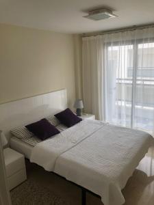 Playa de GandiaにあるApartamento El Eden Playa de Gandíaの大きなベッドと窓のある寝室