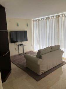 a living room with a couch and a flat screen tv at Apartamento El Eden Playa de Gandía in Playa de Gandia
