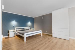 1 dormitorio con cama y pared azul en 18 Deribasivska Street Jacuzzi Apartment, en Odessa