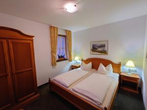 a bedroom with a bed with two tables and two lamps at Landhausferienwohnungen Am Brockenblick Pension in Sorge