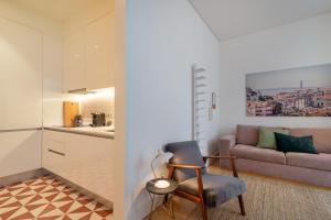 uma sala de estar com uma cadeira e um sofá em Modern 1BDR in Downtown Lisbon by LovelyStay em Lisboa