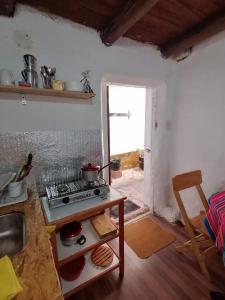 een keuken met een fornuis, een tafel en een raam bij Asiriq Wasi Guest House in Cuzco