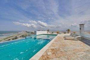 a swimming pool on top of a building with the ocean at Artsy Oceanview Condo W Incredible Rooftop Pool in Cartagena de Indias