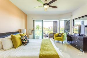 a bedroom with a large bed with a ceiling fan at Luxury Condos at Mareazul Beachfront Complex with Resort-Style Amenities in Playa del Carmen