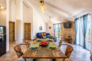 a dining room and living room with a table and chairs at House Villa Getaway in Mirce