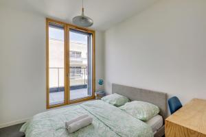 een slaapkamer met een bed, een tafel en een raam bij Chic and spacious apart southern Paris in Massy