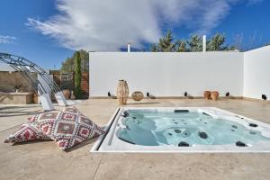 a hot tub on a patio with two pillows at Sia Mare Residence in Faliraki