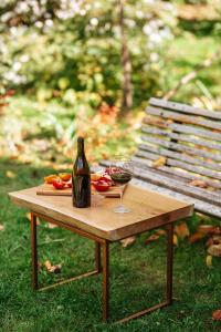 a wooden table with a bottle of wine and a glass at casa akacia in Telavi