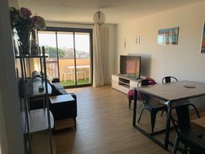 un salon avec une table et une télévision dans l'établissement Plage à pied à 3 mns, à La Seyne-sur-Mer