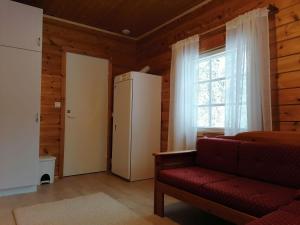 a living room with a red couch and a window at Velhonkieppi in Kittilä