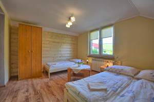 1 dormitorio con 2 camas individuales y ventana en Agroturystyka Chata za wsią, en Uście Gorlickie