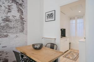 a dining room with a wooden table and a kitchen at Brand new one bedroom heart of Cannes!! in Cannes