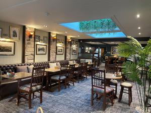 une salle à manger avec des tables et des chaises dans un restaurant dans l'établissement The Bridge Inn, à Holmrook