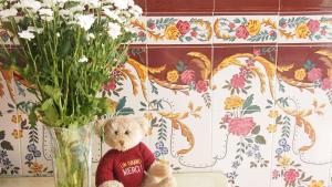 a teddy bear sitting in a vase with flowers at Privat Hotel Liberty Sitges in Sitges