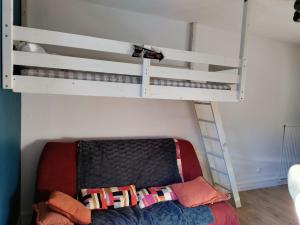 a bedroom with a bunk bed with a couch under it at studio Seignosse Océan (plages et commerces à pied) in Seignosse