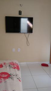 a flat screen tv hanging on a wall at Linda casa com 2 quartos, um com ar e outro com ventilador, e garagem in Parnaíba