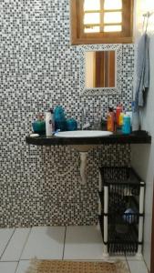 a bathroom with a sink and a mirror at Linda casa com 2 quartos, um com ar e outro com ventilador, e garagem in Parnaíba
