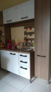 a kitchen with white cabinets and a counter top at Linda casa com 2 quartos, um com ar e outro com ventilador, e garagem in Parnaíba