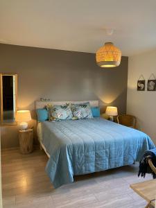um quarto com uma cama azul e uma colcha azul em B&B De Grote Plaats em Hoogstraten