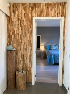 a bedroom with a bed and a wooden wall at B&B De Grote Plaats in Hoogstraten