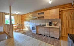 a kitchen with wooden cabinets and a stove top oven at Agroturystyka Chata za wsią in Uście Gorlickie