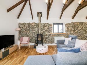 a living room with a stone wall at Beacon Barn in St. Agnes