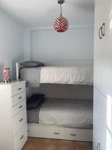 1 dormitorio con litera y armario blanco en Apartamento a pie de playa, en El Portil