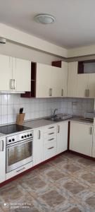 A kitchen or kitchenette at OneBeach Apartman