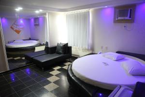 Zimmer mit 2 Betten und einem Zimmer mit violetten Lichtern in der Unterkunft Piramide Stella Maris Adults Only in Salvador