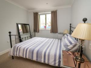 a bedroom with a bed and a lamp and a window at Flat 2 in Pembroke
