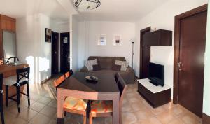 - un salon avec un canapé et une table avec une télévision dans l'établissement Apartamento a pie de playa, à El Portil
