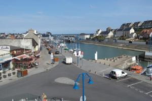 a city street with cars parked next to a river at Vue Sur Mer in Port-en-Bessin-Huppain