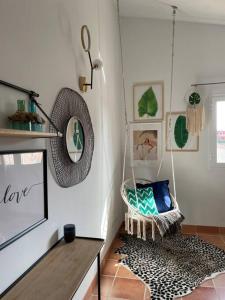 um quarto com uma cadeira suspensa num quarto em Villa 231 Boho House Estrenc - luxury family life - just 5-10min to sandy beach em Sa Ràpita