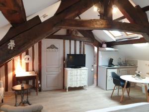 オンフルールにあるD'anciennes ''chambres de bonnes''のキッチン、木製の天井とテレビ付きのリビングルーム