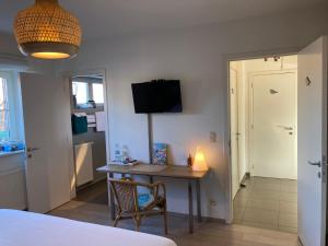 a bedroom with a desk with a lamp and a room at B&B De Grote Plaats in Hoogstraten