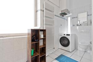 a bathroom with a washing machine and a toilet at Flatista Homes - Old Town in Munich